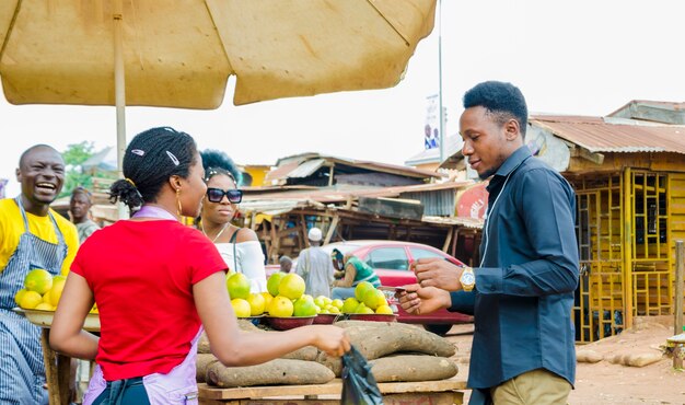 Gruppe junger Afrikaner, die Transaktion in einem Marktplatz machen