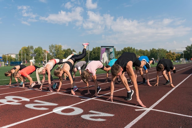 Gruppe junger Athletenläufer, die im neuen Jahr im Stadion im Freien beginnen