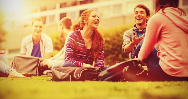 Foto gruppe junger college-studenten, die im park sitzen