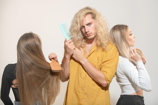 Gruppe junger Frauen und Männer, die Haare kämmen Menschen, die Haare kämmen Mädchen und Kerl verwenden Haarkamm, kümmert sich um Verfahren