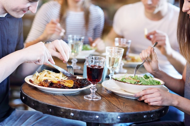 Foto gruppe junger freunde beim essen im restaurant in