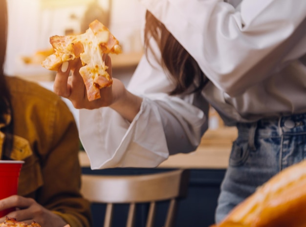 Gruppe junger Freunde, die zu Hause Pizza essen und Spaß haben