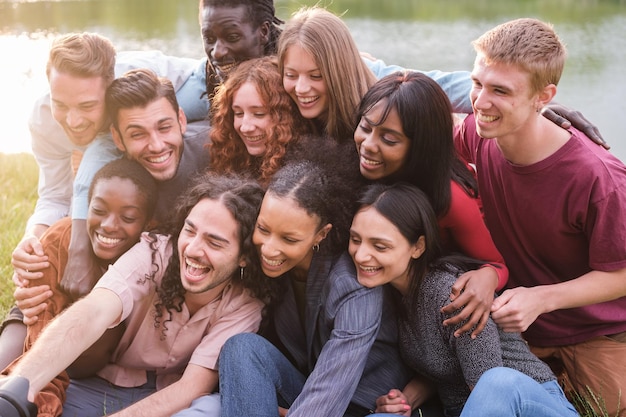 Gruppe junger Freunde unterschiedlicher Herkunft, die gemeinsam im Park ein Selfie im Freien machen Konzept Vielfalt stolz Freundschaft