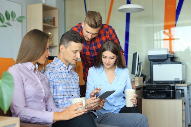 Gruppe junger Geschäftsleute, die ein Treffen haben. Diverse Gruppe junger Designer, die während eines Meetings im Büro lächeln.