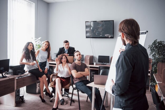 Gruppe junger Geschäftsleute, die im kreativen Büro zusammenarbeiten und kommunizieren