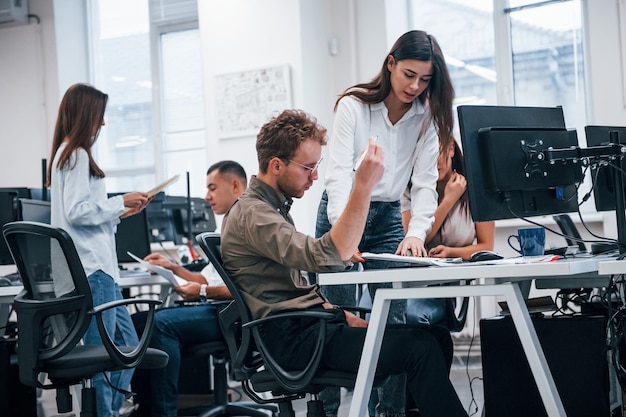 Gruppe junger Geschäftsleute, die im modernen Büro mit Computern arbeiten.