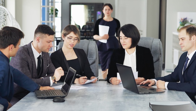 Gruppe junger Geschäftsleute, die sich im Büro treffen und gemeinsam eine wichtige Idee besprechen