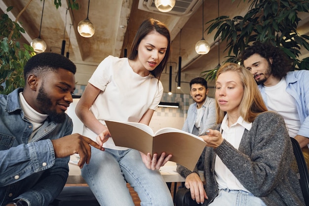 Gruppe junger Geschäftsleute, die während des Treffens im Büro Dokumente besprechen