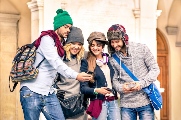 Gruppe junger hipster-touristenfreunde, die sich mit smartphone in der altstadt amüsieren