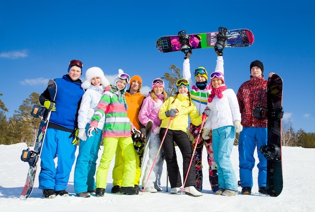 Foto gruppe junger leute mit snowboard im skiurlaub in den bergen