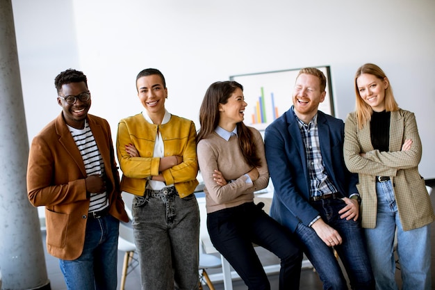 Gruppe junger positiver Geschäftsleute, die zusammen im Büro stehen