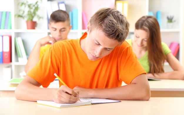 Gruppe junger Studenten, die an der Bibliothek sitzen