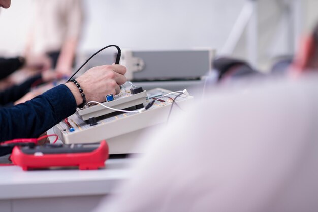 Gruppe junger Studenten, die technische Berufspraxis mit Lehrer im elektronischen Klassenzimmer, Bildungs- und Technologiekonzept machen