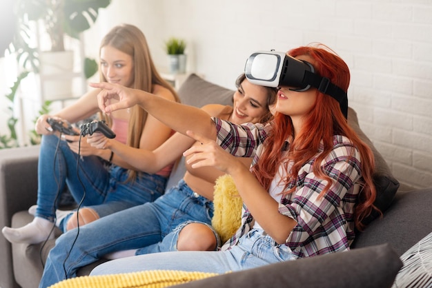 Gruppe junger Teenager-Freunde, die zu Hause Videospiele spielen Teenager, der VR zum Spielen verwendet