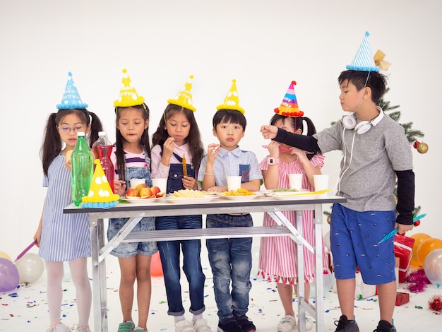 Gruppe Kinder feiern Party und genießen Weihnachtsspaß zusammen, Kinder tauschen Geschenke aus.