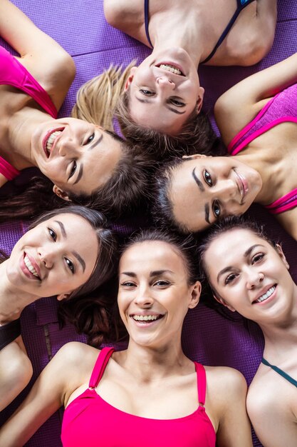 Foto gruppe lächelnde sportliche frauen nach dem training im fitnessstudio fitness-sport-konzept