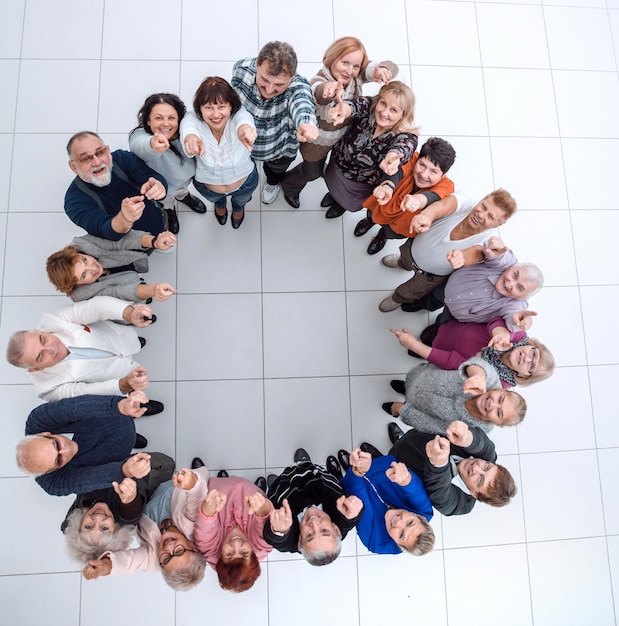 Gruppe lächelnder reifer Menschen, die auf Sie zeigen