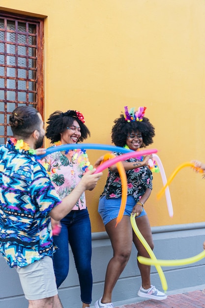 Gruppe lateinamerikanischer Freunde, die beim Straßenkarneval tanzen