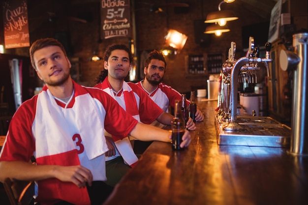 Gruppe männlicher Freunde, die Fußballspiel beobachten