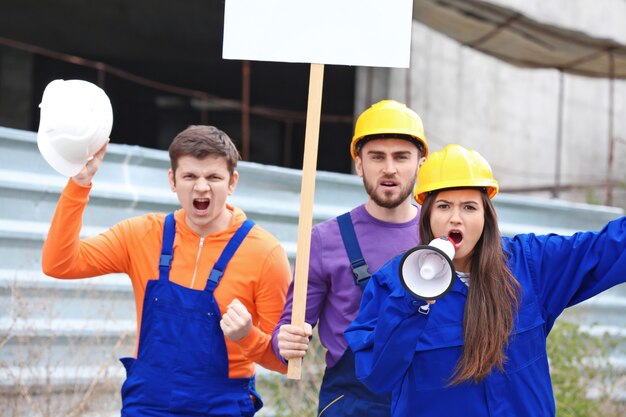 Gruppe protestierender junger Arbeiter mit Plakaten