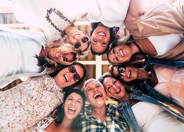 Gruppe schöner Menschen in Freundschaft, die die Party draußen auf der Terrasse genießen Breites Lächeln für das Foto von unten Neun Frauen zusammen