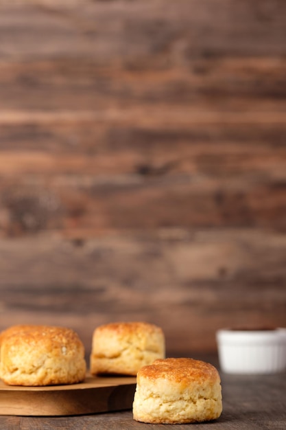 Gruppe Scones auf Holzplatte mit Marmelade auf dem Tisch