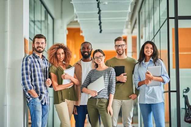 Gruppe selbstbewusster junger Mitarbeiter, die für Teamfoto posieren