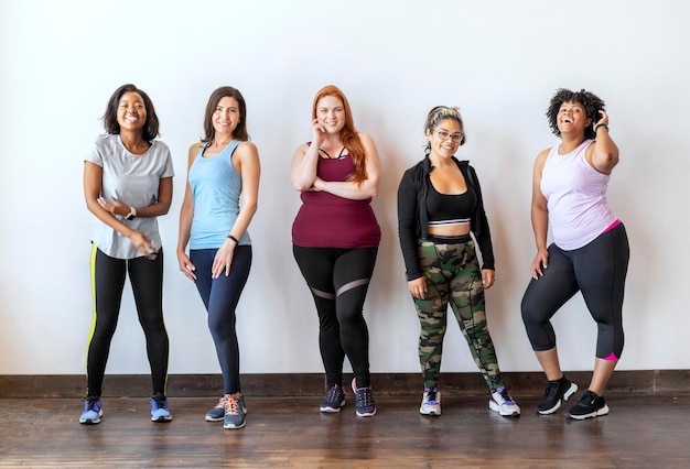 Gruppe sportlicher Frauen, die an einer Mauer stehen