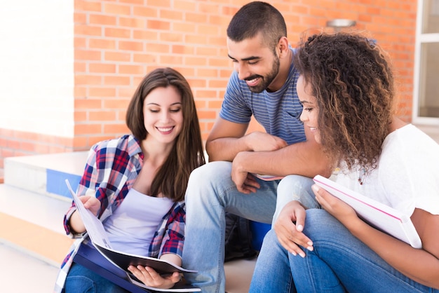 Gruppe Studenten, die auf Schultreppen sitzen