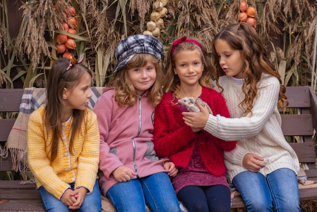 Gruppe süßer kleiner Mädchen, die einen Igel in ihren Armen halten Familienherbstporträt