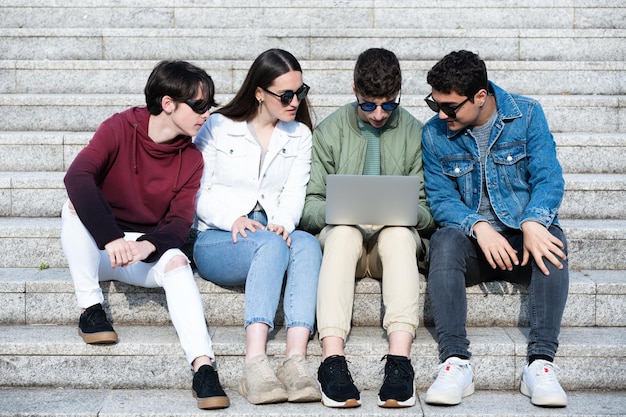 Gruppe Teenagerstudenten, die auf Treppe sitzen