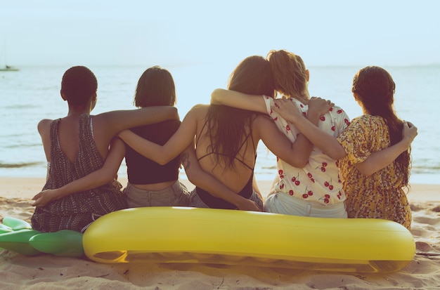 Foto gruppe verschiedene frauen, die zusammen am strand sitzen