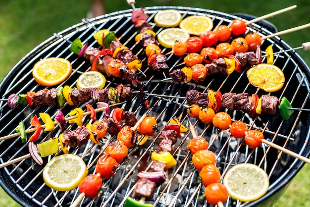 Gruppe verschiedene Freunde, die draußen Grill grillen