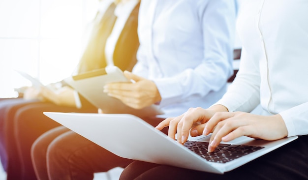 Gruppe verschiedener Geschäftsleute, die im Büro arbeiten, Nahaufnahme. Frau, die mit Laptop arbeitet. Konferenz-, Tagungs- oder Schulungskonzepte.