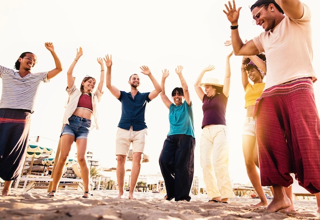 Gruppe verschiedener Leute, die zusammen auf einer Strandparty tanzen