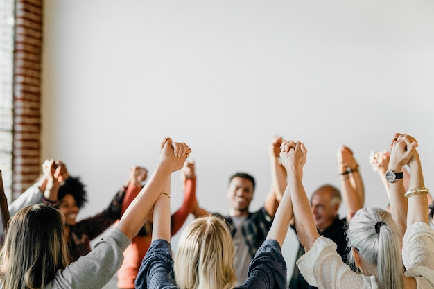 Gruppe verschiedener Menschen, die Hände in die Luft halten