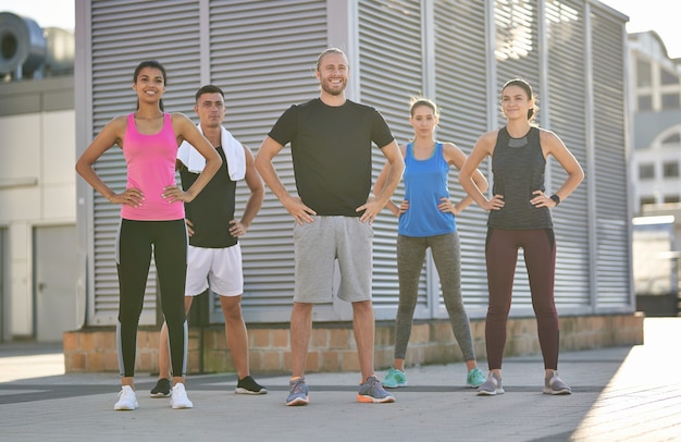 Gruppe verschiedener Sportler, die in der Stadt posieren