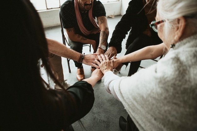 Gruppe verschiedener Teams, die sich in der Mitte zusammenschließen