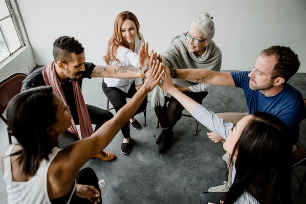 Gruppe verschiedener teams, die sich in der mitte zusammenschließen