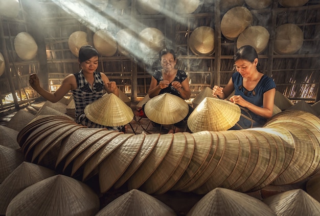 Gruppe vietnamesischer Handwerkerinnen, die den traditionellen Vietnam-Hut herstellen