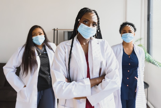 Gruppe von afroamerikanischen Ärztinnen in Schutzmasken auf ihren Gesichtern