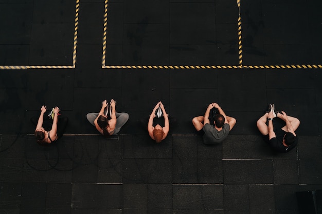 Gruppe von Athleten, die sich zusammen strecken, um die Crossfit-Übungsroutine zu starten.