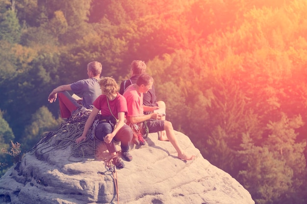 Gruppe von Bergsteigern auf der Spitze der runden Felsen im Waldhintergrund