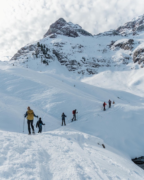 Gruppe von Bergsteigern, die im Winter an einem sonnigen Tag in den Pyrenäen eine Route mit Schneeschuhen machen