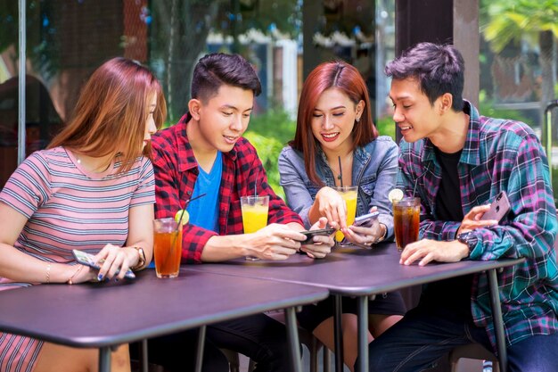 Gruppe von College-Studenten, die auf ihr Mobiltelefon schauen