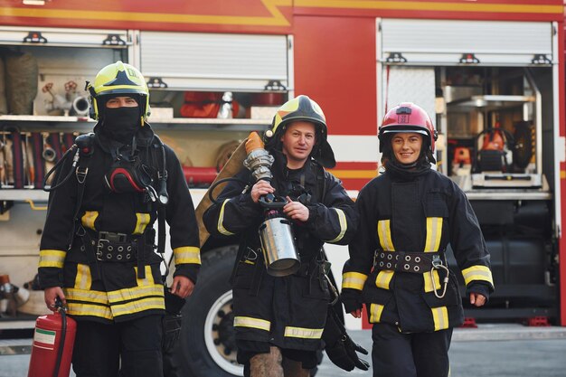 Gruppe von Feuerwehrleuten in Schutzuniform, die sich im Freien in der Nähe eines Lastwagens befindet