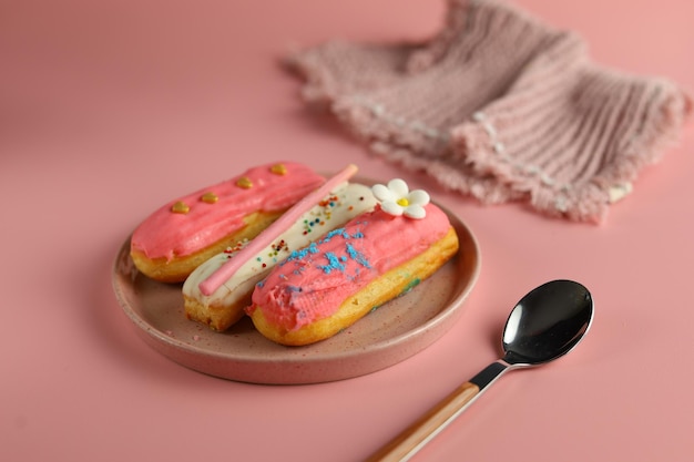 Gruppe von französischen köstlichen Dessert Eclair mit rosa Farbe auf rosa Hintergrund für Valentine-Konzept