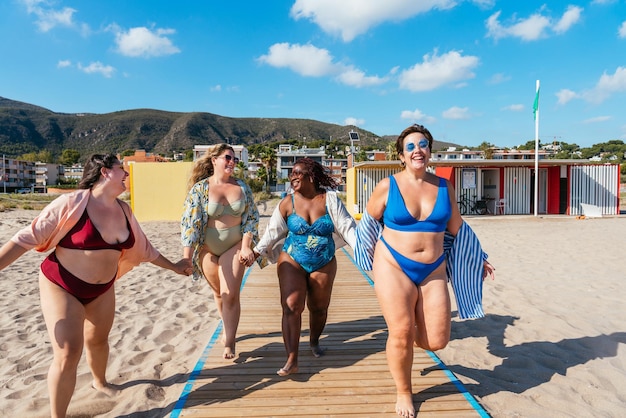 Gruppe von Frauen in Übergröße mit Badebekleidung am Strand