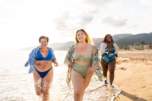 Gruppe von Frauen in Übergröße mit Badebekleidung am Strand