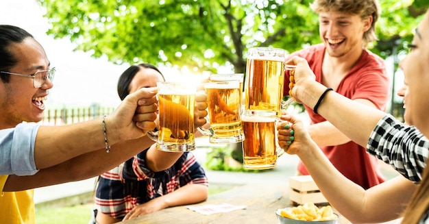 Gruppe von Freunden, die Biergläser im Brauereikneipengarten zujubeln